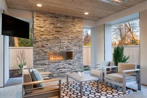 A luxurious stone patio with a 3-season sunroom and outdoor living area. | Bayside Pavers