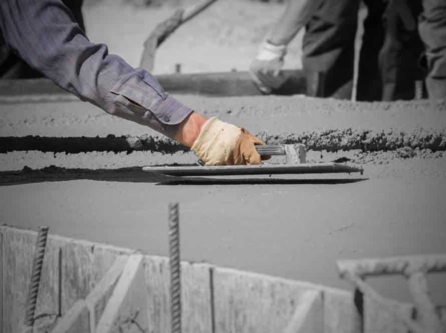 Construction workers leveling concrete pavement.